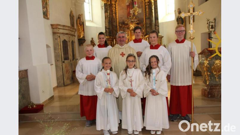 An die schöne Feier ihrer Erstkommunion werden die drei Mädchen wohl gerne zurückdenken. Das Foto zeigt sie mit Pfarrer Alfons Kaufmann und den Ministranten. Bild: frd