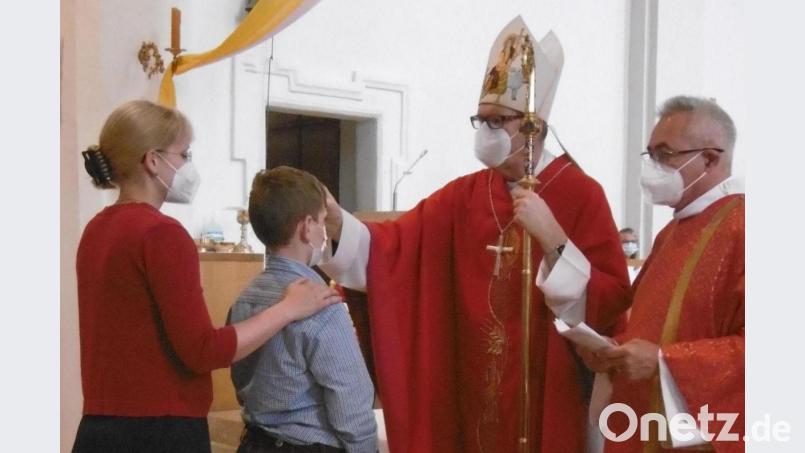 Weihbischof Josef Graf, assistiert vom Hahnbacher Diakon Dieter Gerstacker, spendet das Sakrament der Firmung. Bild: mma