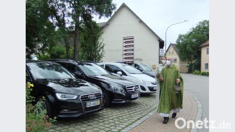 Ruhestandspfarrer Josef Dotzler besprengt jedes einzelne Fahrzeug mit Weihwasser und wünscht den Fahrern allzeit gute Fahrt. Bild: gm