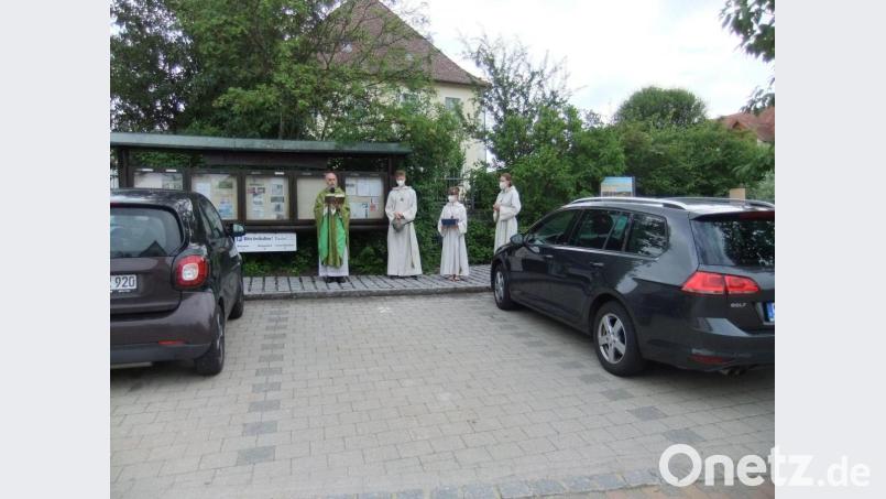 Seelsorger Josef Dotzler mit Meßdienern beim Gebet am Kirchplatz. Bild: gm