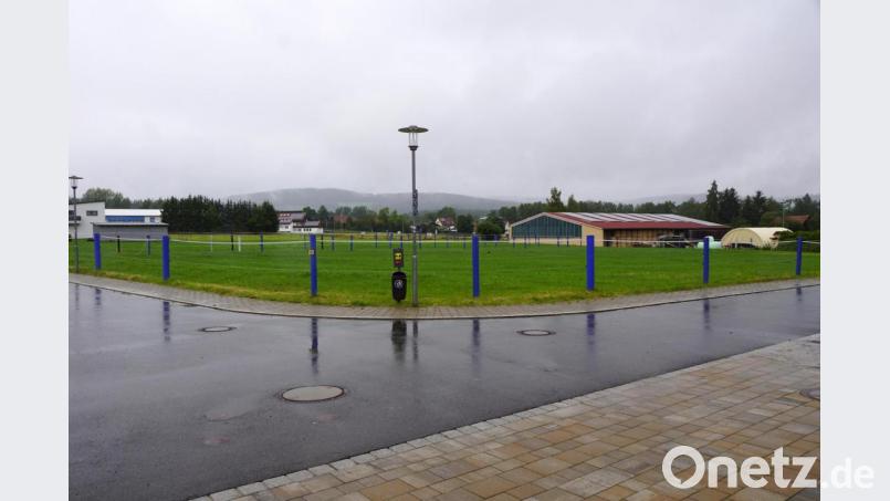 Die blauen Säulen entlang der Straße „Steinäcker“ grenzen die Koppel des Reitstalls ab. Entlang der Straße werden wieder fünf Bauplätze ausgewiesen, so wie es der Bebauungsplan vor 15 Jahren beinhaltet hat. Die entlang der Straße vorgesehene Schutzhecke weicht zur Reithalle (Hallengebäude mit rotem Dach) zurück. Bild: bkr