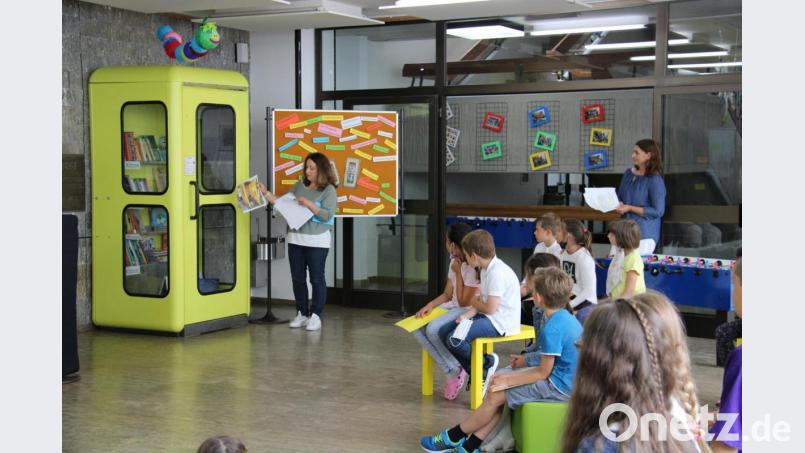 Die ehemalige Elternbeiratsvorsitzende Marion Schäffler erklärte den Grundschülern in der Aula, wie die Bücherzelle einmal ausgesehen hat. Bild: prh