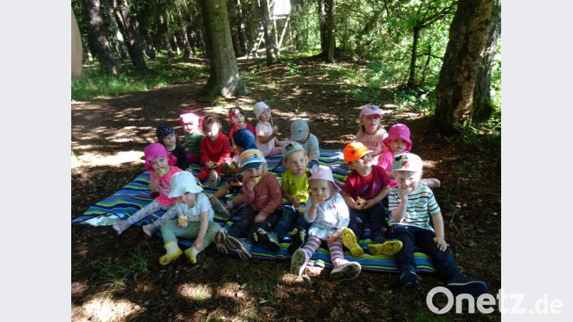 Auf einer Decke am Waldboden sitzend machten die Mädchen und Buben Brotzeit. Bild: Kinderhaus St. Michael/exb