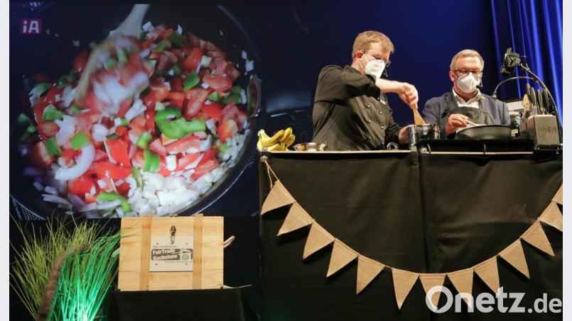 Live auf der Bühne im ACC – für die Zuschauer auf der Leinwand im Hintergrund übertragen – kochen Hendrik Meisel und Martin Preuß (von links) mit Fairtrade-Waren ein leckeres Menü. Bild: Wolfgang Steinbacher