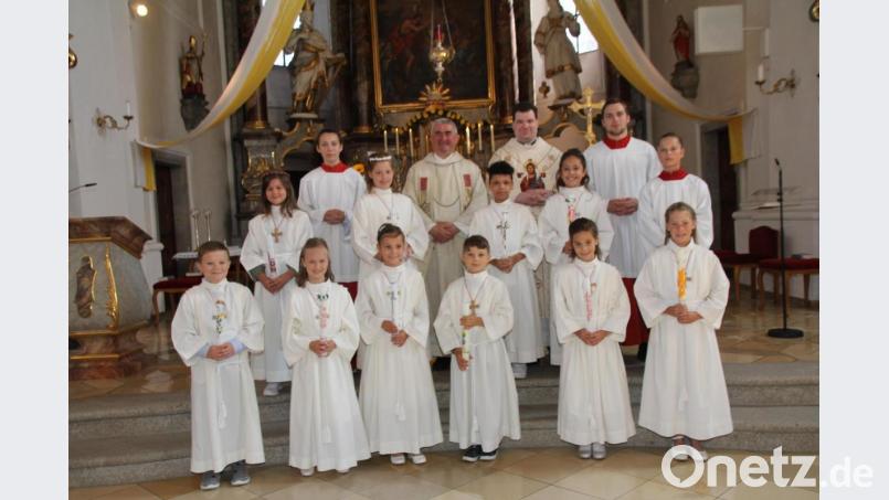 Zehn Kinder aus Oberviechtach durften am Samstag zum ersten Mal aus der Hand von Stadtpfarrer Alfons Kaufmann und Kaplan Florian Fronhöfer (hinten Mitte) die heilige Kommunion empfangen. Bild: frd