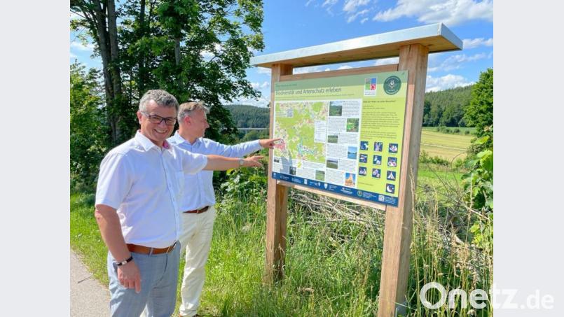 Jürgen Donhauser (rechts) und der Neunburger Bürgermeister Martin Birner sehen sich eine der Infotafel an, die bis Anfang August an Wanderwegen im ganzen Neunburger Umland angebracht werden sollen. Bild: Stadt Neunburg vorm Wald/exb