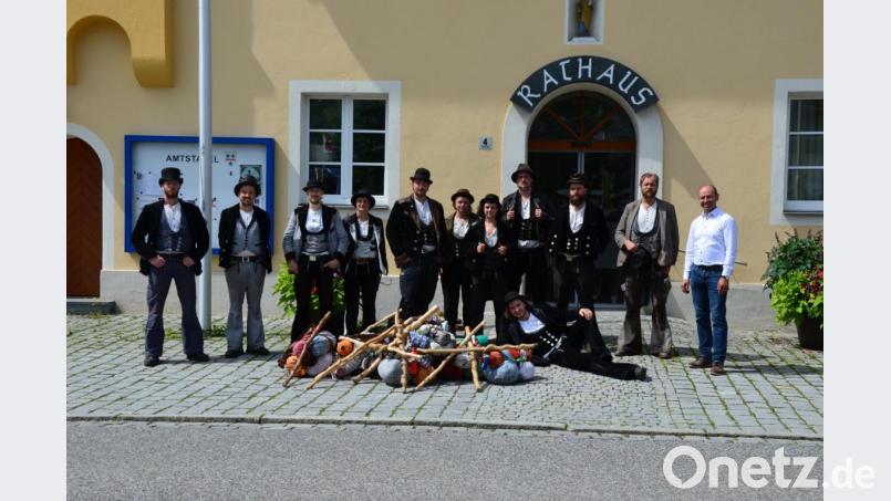 Zimmerergeselle Christoph Rester (liegend) aus Rannahof, Ensdorfs Bürgermeister Hans Ram (rechts) und die zehn Handwerksgesellen, die Christoph Rester auf seinem ersten Stück der Walz begleiteten. Bild: Eva Groeninger