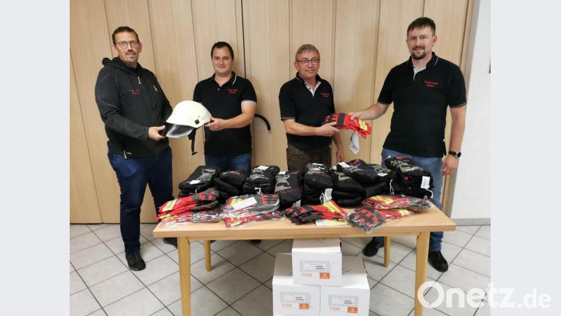 Feuerwehrvorsitzender Jürgen Bösl überreicht an Kommandant Josef Kleber (von rechts) die neuen Handschuhe und stellvertretender Kommandant Georg Rauch durfte von 2. Vorsitzenden Stefan Schönberger (von links) die neuen Helme entgegen nehmen. Bild: gz