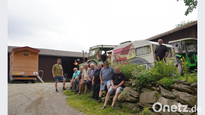 Christoph Ertl (links) zeigt den sieben Traktorwallfahrern (sitzend) aus Unterfranken das Oldtimermuseum in Woppenrieth. Mit dabei: Oma Monika Gollwitzer und Papa Peter Ertl (rechts). Bild: fvo
