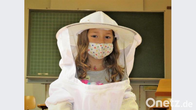 Was macht ein Imker? Das lernten die Grundschulkinder der Klassen 1a und 1b bei einem umfangreichen Projekttag. Tereza durfte dabei den Schutzanzug eines Imkers überziehen. Bild: ubb