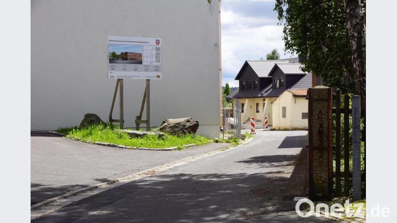 Wo die Bautafel steht, sollen die Fahrradständer für die Besucher des Bürgerhauses platziert werden. Im Eingangsbereich lehnt die Regierung diese ab. Gleichzeitig wird die weiße Asphaltdecke nach vorne verlegt. Bild: bkr