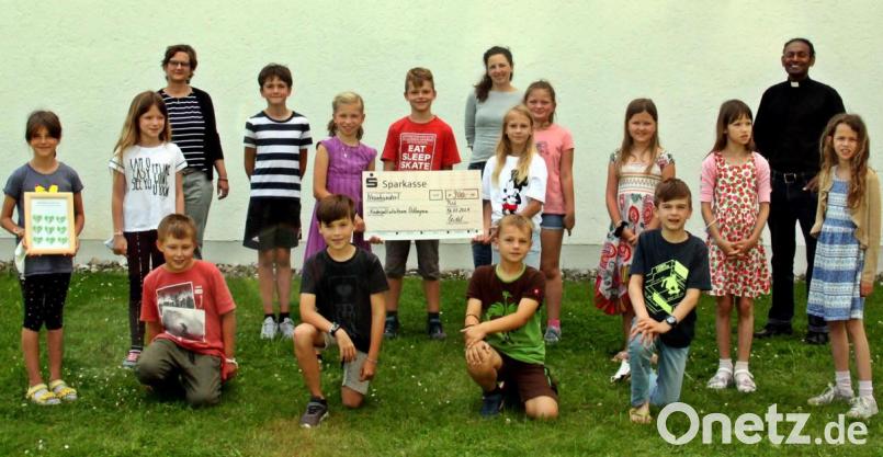 Die Erstkommunionkinder überreichen eine Spende von 900 Euro, nachdem sie auf Gegengeschenke verzichtet hatten. Auf Initiative von Marion Seidel (hinten links) kam es nun zur Übergabe an , Christina Weiß (Mitte). Bild: zer