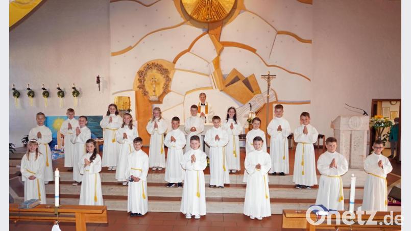 Nach der gemeinsamen Dankfeier am später Sonntagnachmittag stellen sich die 20 Erstkommunionkindern 2021 der Pfarrei St. Sebastian mit Pfarrer Norbert Götz vor dem Altar. Bild: fvo