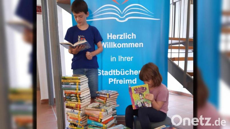 Korbinian und Klara haben in der Pfreimder Stadtbücherei schon mal kurz hinein geschmökert, um herauszufinden, welcher Band in dem Sortiment an nagelneuer Ware ihnen gefallen könnte. Bild: Sittl/exb