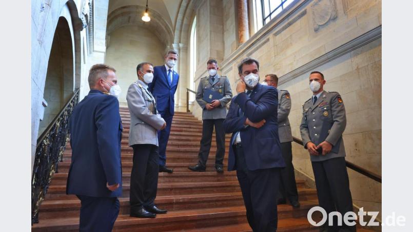 Small-Talk auf der Treppe: Ministerpräsident Markus Söder (Dritter von rechts) spricht mit Soldaten am Rande des Festakts zur Verleihung des Ehrenzeichens. Bild: Karl-Josef Hildenbrand/dpa
