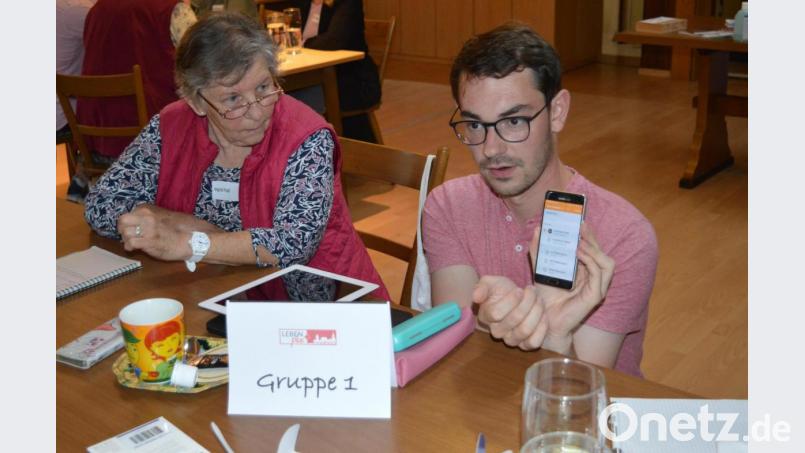 In kleinen Gruppen erklärten die Helfer, wie hier Jugendbeauftragter Sebastian Wiedemann (rechts), den Senioren die Funktionen des Handys. Bild: Cornelia Stahl/exb