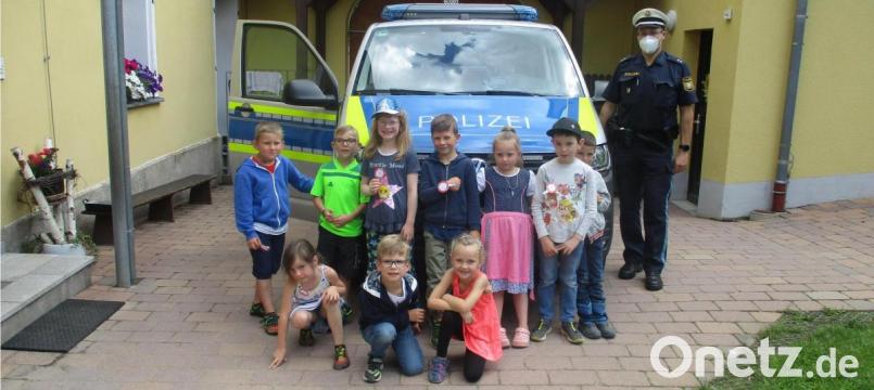 Die Vorschulkinder mit Hauptkommissar Carsten Landgraf vor dem interessanten Polizeiauto. Bild: njn