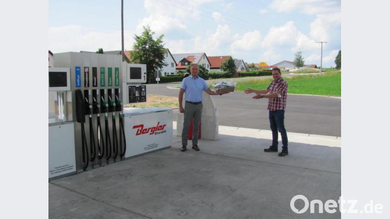 Am offiziellen Eröffnugnstag der neuen Tankstelle überreichte Bürgermeister Richard Kammerer (links) an Gerhard Bergler (rechts) einen Präsentkorb und freute sich auch für die Einwohner, dass endlich wieder in Mantel getankt werden kann. Gerhard Bergler nahm auch gleich die Anregung auf, dass die Beleuchtung am Preismast nachts zu hell ist und ließ die Anlage herunterdimmen. Bild: sei