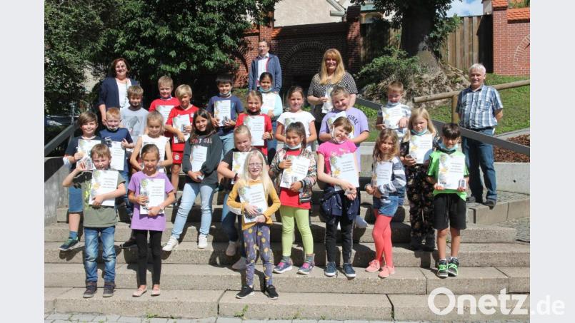 Rupert Seitz, Stefanie Ach, Martin Neumann und Christa Walbrunn (hinten, von rechts) freuen sich mit den Kindern, die beim Wettbewerb &quot;Kinder schreiben Geschichte&quot; mitgemacht haben. Bild: pi