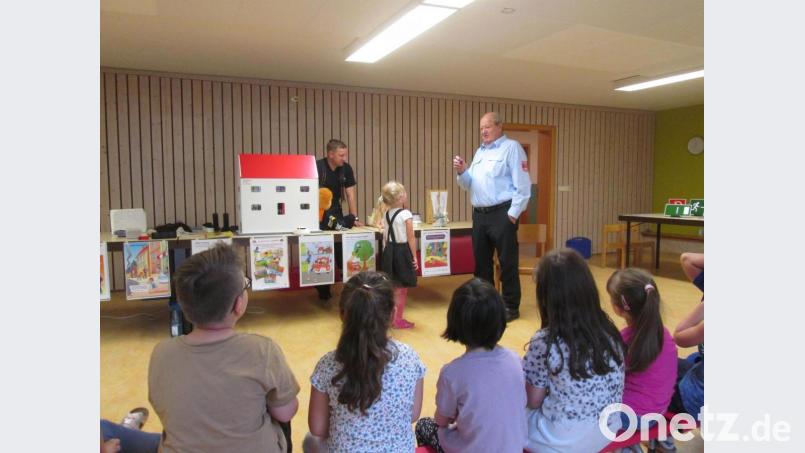 Ehrenkommandant Otto Weiß und Daniel Kircher (von rechts) waren zur Brandschutzerziehung in den beiden Kinderhäusern der Stadt zu Gast. Bild: Bianca Schwägerl/exb