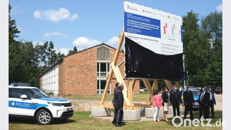 Die Enthüllung der Bautafel war der symbolische Startschuss für die Sanierung des "Hauses 3" (Hintergrund) auf dem ehemaligen BGS-Gelände in Schwandorf. Dort soll das Zentrum der deutsch-tschechischen Polizeiarbeit einziehen. Bild: Hirsch