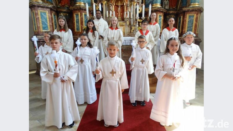 Sieben Kinder empfingen in der Pfarrkirche St. Georg in Schlicht die Erstkommunion. Zusammen mit den Ministranten und Stadtpfarrer Pater Robin Xavier stellten sie sich nach dem Gottesdienst vor dem Hochaltar zum Erinnerungsfoto auf. Bild: ct