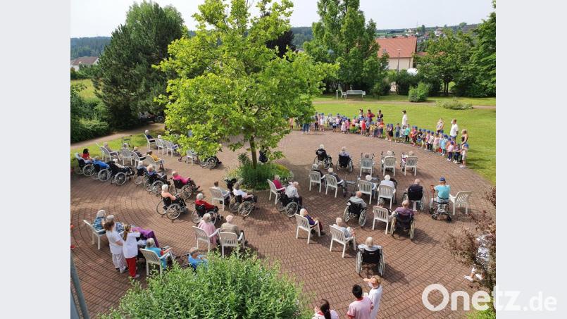 Im Garten des AWO-Heimes die singenden Kindern und die Senioren. Bild: e