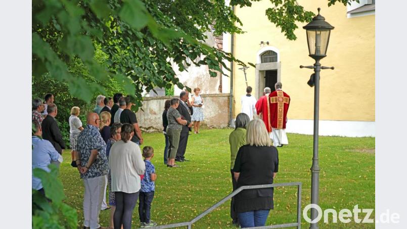 Pfarrer Norbert Götz und Diakon Janucz Szubartowicz ziehen vom Kirchhof in die Filialkirche St. Jakobus zur Festmesse. Viele Gläubige verfolgen den Gottesdienst im Kirchhof. Bild: fvo