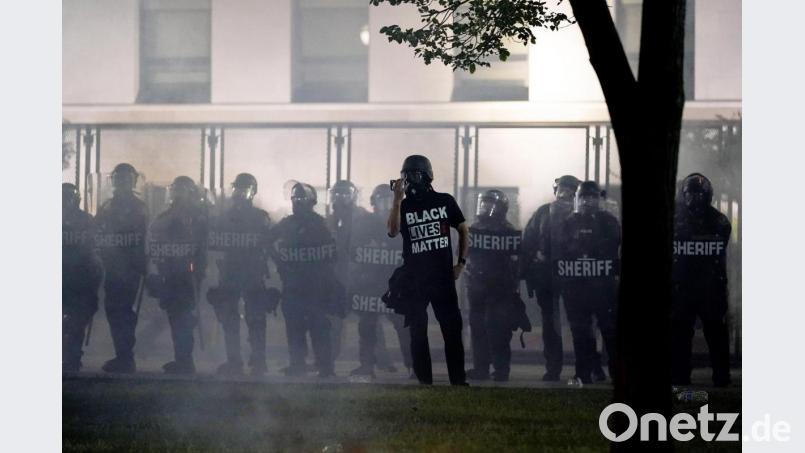 Black Lives Matter – schwarze Leben zählen, schwarze Leben sind wichtig – steht auf dem T-Shirt dieses Demonstranten in Kenosha, USA. Er hat sich vor Polizisten postiert. Mehrere Schüsse in den Rücken des schwarzen Amerikaners Jacob Blake bei einem Polizeieinsatz im US-Bundesstaat Wisconsin haben Entsetzen und Proteste ausgelöst. Bild: Morry Gash/AP/dpa