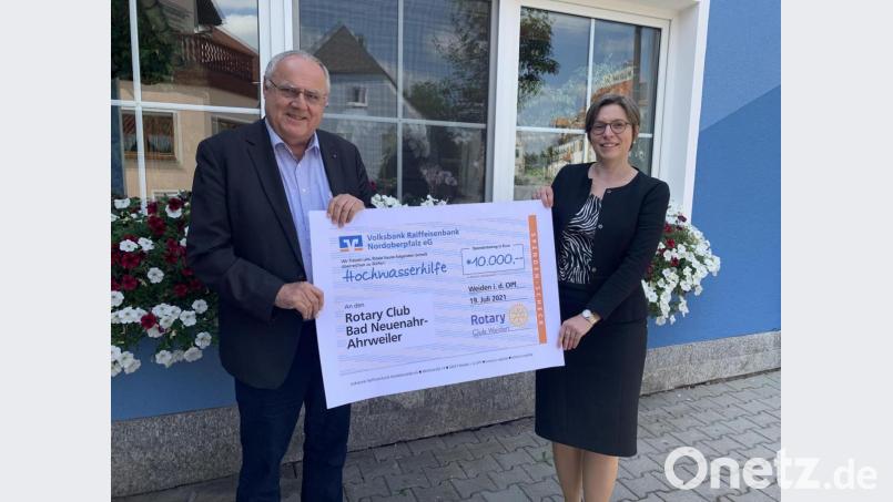 Lothar Höher und Sonja Keller vom Rotary-Club Weiden halten den Scheck für die Hochwasseropfer in Händen. Bild: Rotary-Club/exb