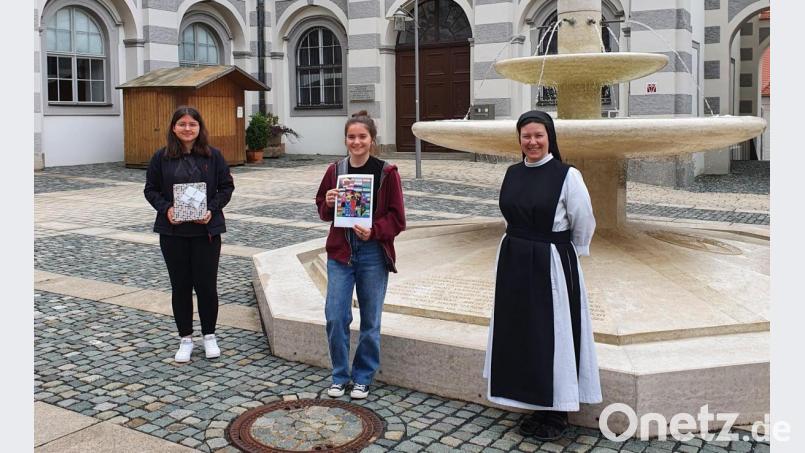 Konrektorin Sr. M. Raphaela und Schülersprecherin Veronika Zintl bedankten sich bei Eva-Marie Grabis für ihr Kunstwerk und übergaben ihr ein kleines Präsent dafür. Das Bild unter dem Motto &quot;Gemeinsam sind wir stärker&quot; wird den neuen Schulplaner zieren. Bild: flt