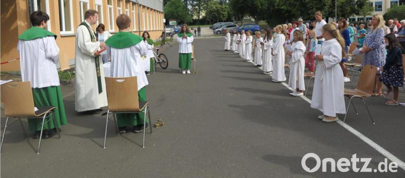 Die Erstkommunionkinder nahmen an der Familienmesse im Freien mit Alben, aber ohne Kerzen teil. Bild: jzk