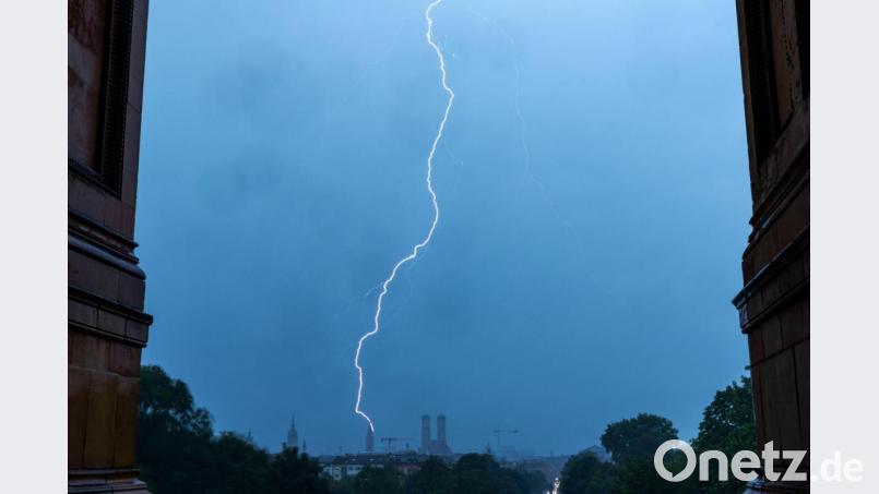 Ein Blitz schlägt in den Turm des Münchner Rathauses ein. Archivbild: Peter Kneffel/dpa