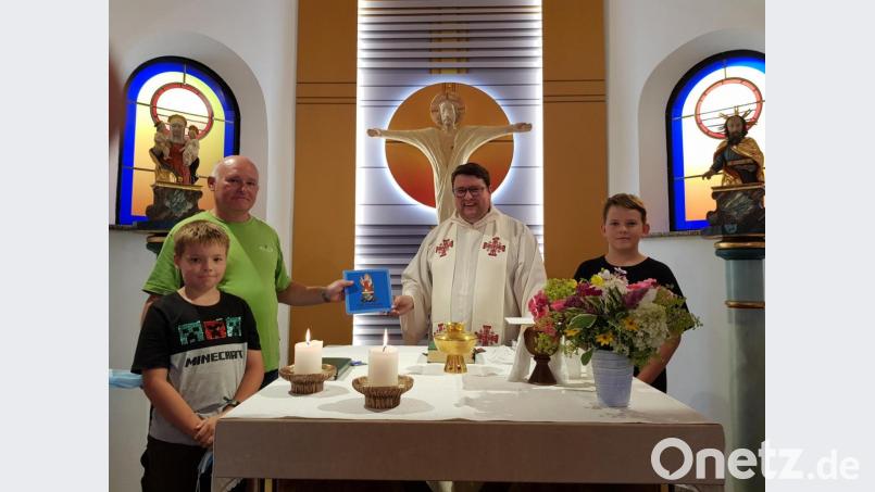 Pfarrer Udo Klösel feierte den ersten Gottesdienst zum Patrozinium St. Anna in Gebhardsreuth. Reinhold Baier überreicht ihm ein Büchlein wie diese Kapelle entstanden ist. Bild: gi