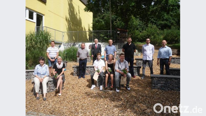 Die Schulbesten Benjamin Schöpper, Elena Götz und Dominik Bolha (Mitte von links), mit Rektorin Helga Gradl und Klassenlehrerin Sabine Stopfer-Birner (vorne, von links), den Bürgermeistern Hans Ram (rechts), Erwin Geitner (Vierter von rechts) und Martin Bauer (Fünfter von rechts) sowie einigen Sponsoren. Bild: tra