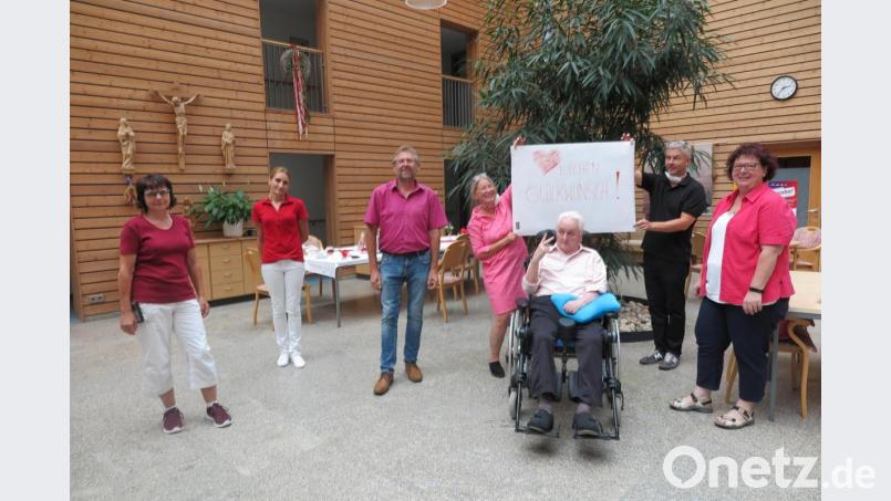 „Herzlichen Glückwunsch“ stand auf dem Schild, das die Mitarbeiterinnen im Haus Falkenstein für Theo Laux angefertigt hatten. Gehalten wurde es von Sohn Günter und Schwiegertochter Ina. Auch Heimleiterin Claudia Heier (rechts) und Zweiter Bürgermeister Hermann Schraml (links) gratulierten. Bild: jzk