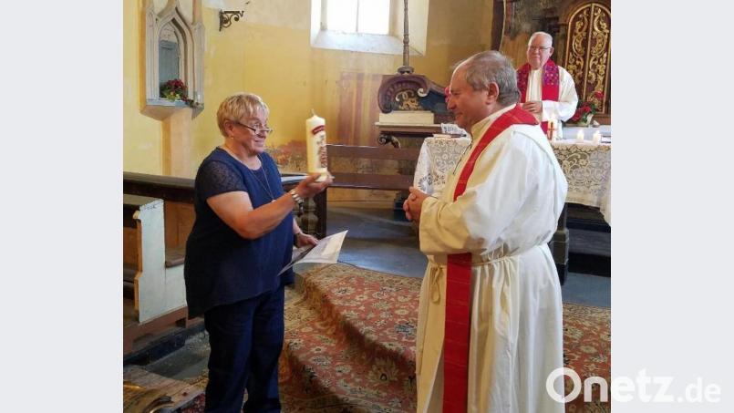 Ingrid Leser von der Interessengemeinschaft Bruck überreichte Pfarrer Šašek zum Abschied eine Kerze. Bild: exb