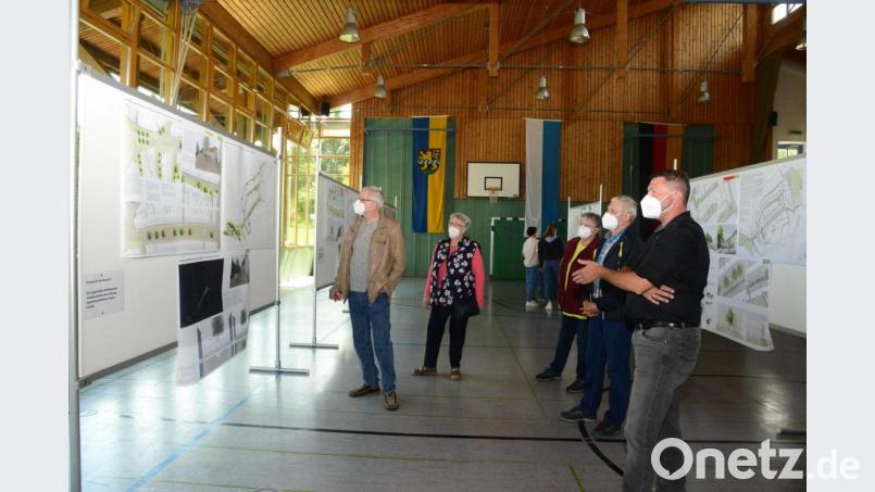 Bürgermeister Rainer Rewitzer präsentiert den Besuchern die eingereichten Pläne und Ideen der Landschaftsarchitekten zur Marktplatzgestaltung. Bild: bey