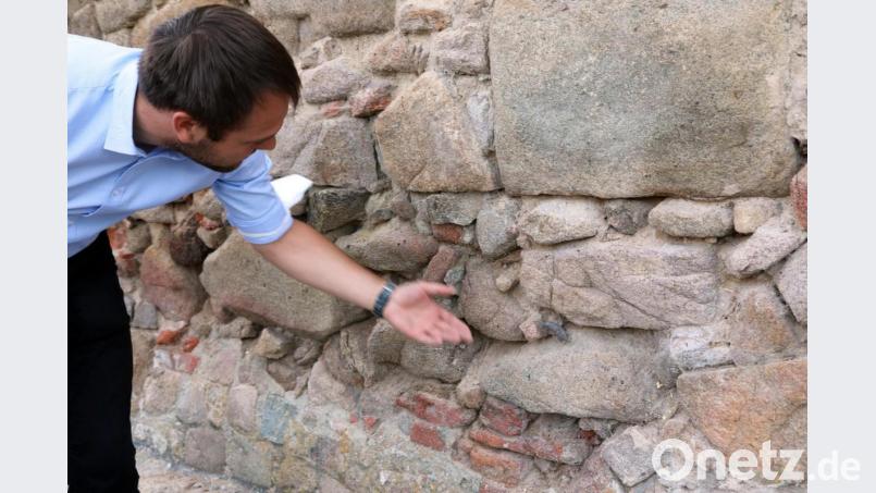 Der Geschäftsleiter der Verwaltungsgemeinschaft Nabburg, Thomas Prey, macht auf das Problem aufmerksam: Fugenmaterial rieselt aus der Stadtmauer. Wenn nichts geschieht, folgen irgendwann die Steine. Bild: Gerhard Götz