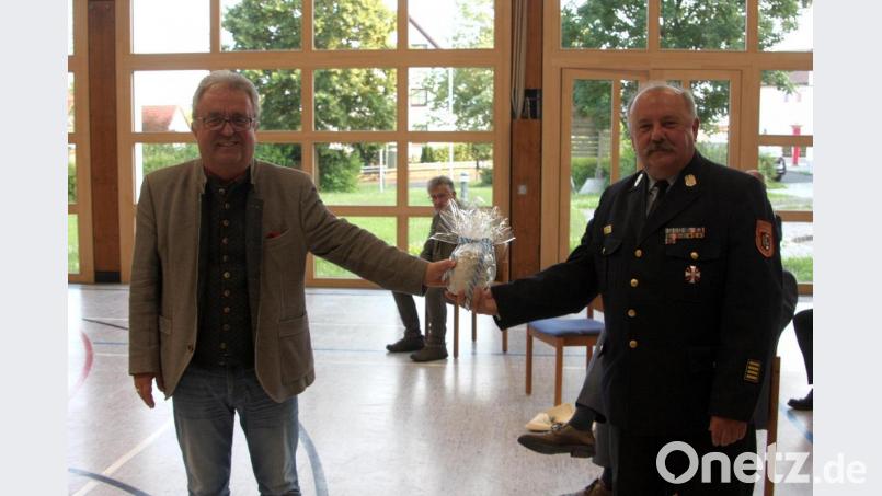 Mit einem Bierkrug und einem darin enthaltenen Gutschein bedankte sich der Wiesauer Bürgermeister Toni Dutz (links) bei Kreisbrandrat Andreas Wührl (Wiesau) für 50 Jahre Dienst bei der Feuerwehr. Bild: wro
