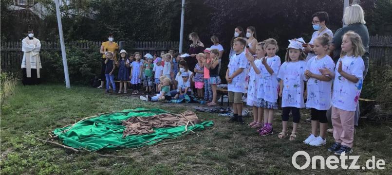 Bild zeigt die Kinder mit dem Kinderhausteam und Pfarrer Pater Anish George bei der Abschlussandacht im Pfarrgarten. Bild: soj