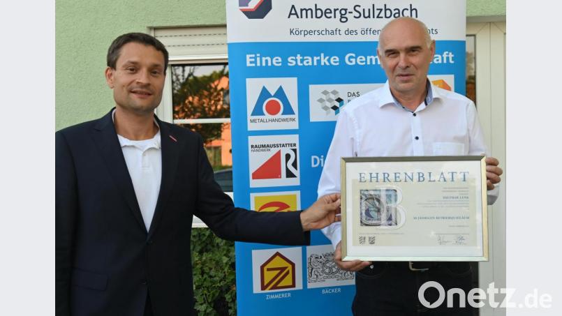 Alexander Stahl (links), Geschäftsführer der Handwerkskammer Niederbayern-Oberpfalz, hat bei der Delegiertenversammlung der Kreishandwerkerschaft Amberg-Sulzbach das Ehrenblatt der Handwerkskammer an Dietmar Lenk überreicht. Bild: gf