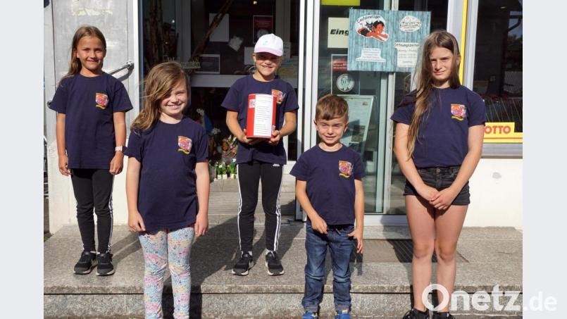 Lena, Marie, Annika, Elias und Marlene (von links) von den Feuerdrachen mit der Spendendose vom Dorfladen. Bild: bkr