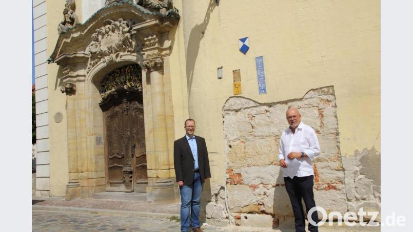 Stadtpfarrer Thomas Helm und Kirchenpfleger Josef Beer (von links) von St. Martin machen sich ein Bild von den baulichen Schäden im Sockelbereich der Schulkirche. Die Sanierungsarbeiten sind dieser Tage angelaufen. Bild: ads