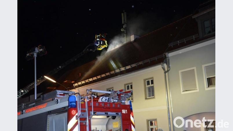 Mit der Drehleiter versuchen die Feuerwehrmänner, von außen an den Brandherd zu kommen. Die ganze Nacht dauert der Löscheinsatz in Waldthurn. Bild: dob