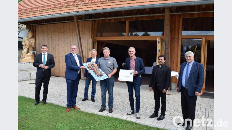 Die Schlüsselübergabe von Architekt Markus Rösch (Dritter von rechts) an Bürgermeister Franz Grabinger (Zweiter von links) besiegelte die Inbetriebnahme des Schlossbauernhofes. Als künftiger &quot;Schlossherr&quot; konnte Franz Geiger (Mitte) den Schlüssel entgegennehmen. Zu den Gratulanten zählten Landrat Thomas Ebeling, Landtagsabgeordneter Joachim Hanisch, Pfarrvikar Pater Binu Kurekatill und Bundestagsabgeordneter Karl Holmeier. Bild: bnr