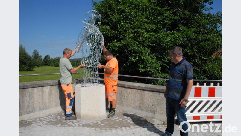Die beiden Gemeindearbeiter Manuel Müller und Christian Lautenschlager bauten die Skulptur auf. Mit dabei Bürgermeister Peter Braun. Bild: pop