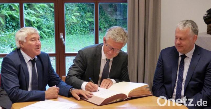 Der ukrainische Botschafter Andriy Melnyk (Mitte) trägt sich beim Wirtschaftsgespräch in Kastl, organisiert von MdB Alois Karl (links) , im Beisein von Landrat Richard Reisinger ins goldene Buch des Landkreises Amberg-Sulzbach ein. Bild: jp