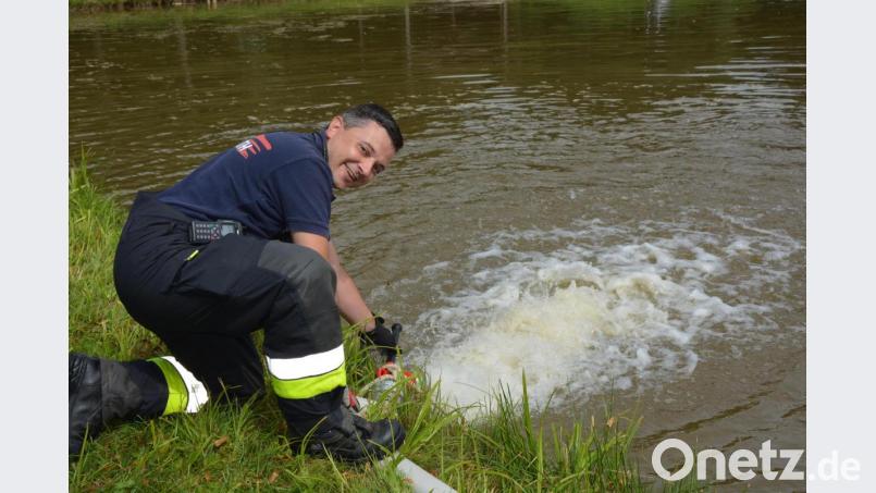 Kommandant Stefan Kreuzer koordinierte den Großeinsatz am Wochenende. Hier lässt er gerade die letzten Liter Wasser in den Badeweiher ein. Bild: jr