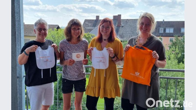 Ute Schieder (Leiterin der Beratungsstelle), Michaela Mußemann (Bevollmächtigte), Franziska Seidl (Vorstandsmitglied des Fördervereins) und Stephanie Bogner (Schwangerenberaterin) zeigen, was in den orangefarbenen Stoffbeuteln von Donum Vitae steckt. Bild: Sieglinde Biller/Donum Vitae/exb
